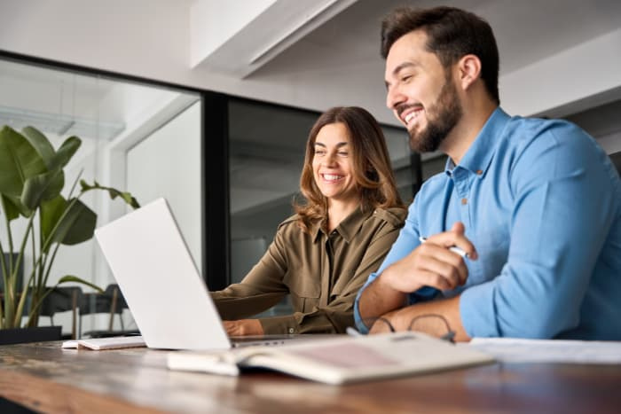 a man and a woman looking at a laptop together