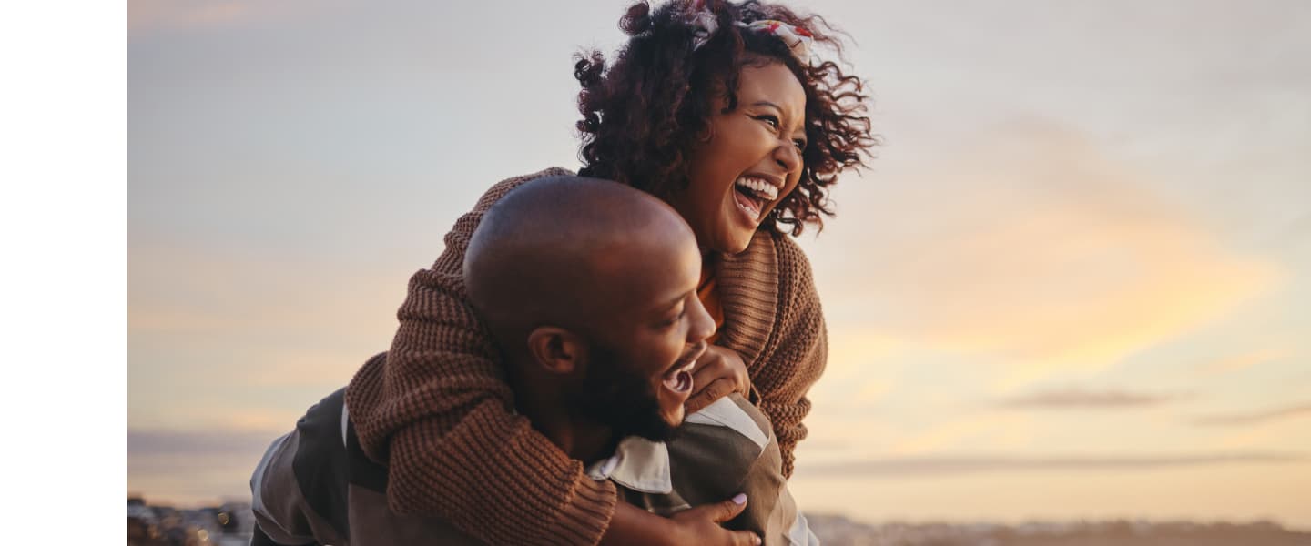 Black couple enjoying benefits of Money Market Plus account while spending time together at the beach