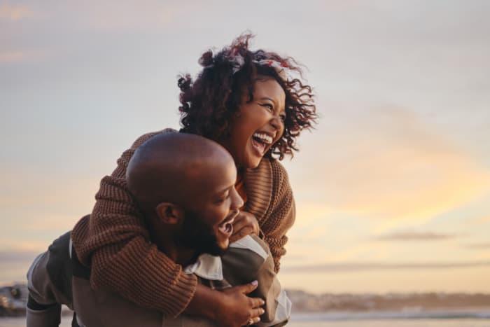 Black couple enjoying benefits of Money Market Plus account while spending time together at the beach